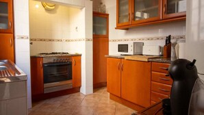 Una cocina con armarios de madera, un microondas y una estufa.