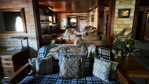 Una habitación acogedora con una cama, un escritorio y una silla. Hay una ventana y una puerta que da a otra habitación.
