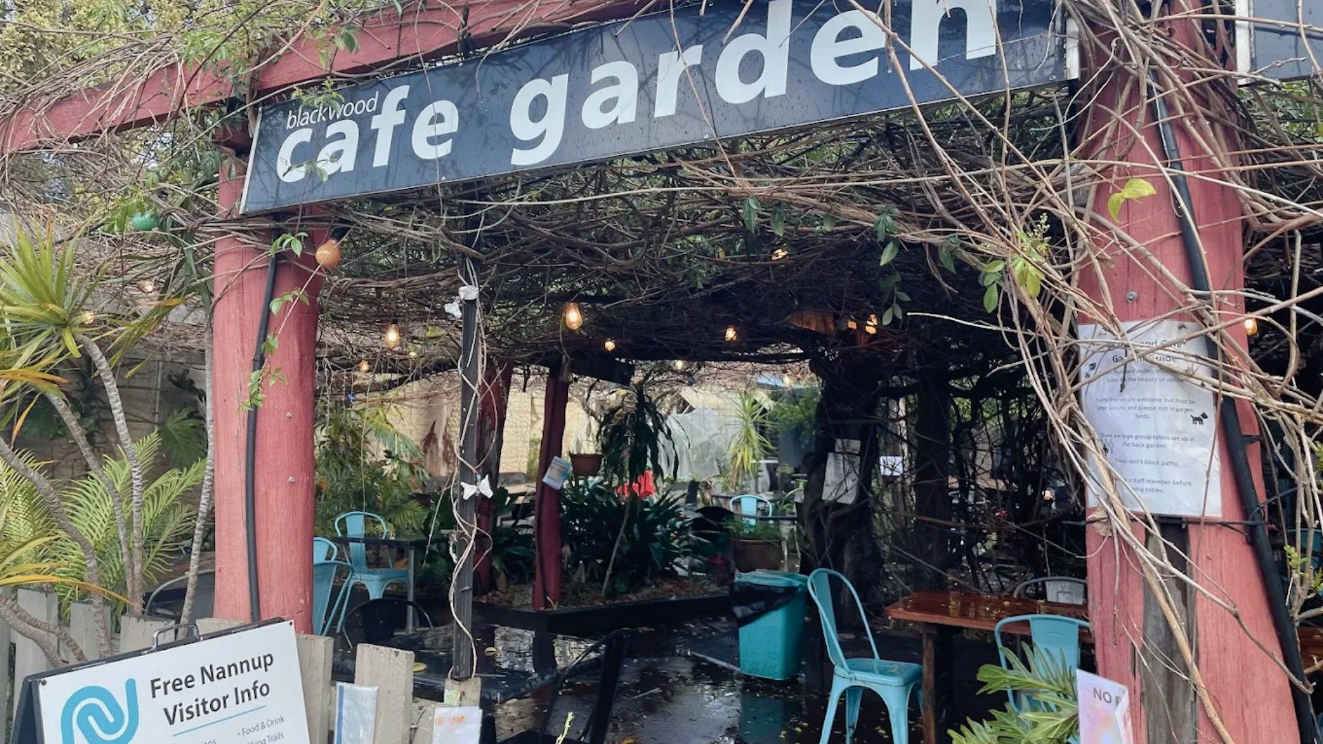 A cafe garden with a sign reading 'blackwood cafe garden'. There are outdoor seating areas with tables and chairs.