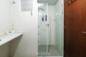 A bathroom with a glass shower enclosure, a wooden door, and a white tiled wall. - Apt With Balcony 400m From the Sea, View BC Rft505 (Balneário Camboriú)
