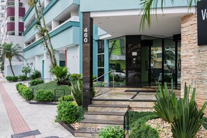 A modern building with a glass entrance, numbered 460, surrounded by well-maintained greenery and a paved walkway. - Apt With Balcony 400m From the Sea, View BC Rft505 (Balneário Camboriú)