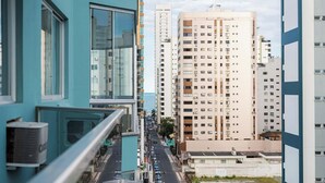 A high-rise building with multiple floors, large windows, and balconies.