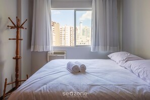 A hotel room with a bed, a wooden coat rack, and a window with curtains. - Apt With Balcony 400m From the Sea, View BC Rft505 (Balneário Camboriú)