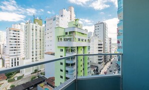 A high-rise residential building with multiple balconies, a clear view of the street below, and a blue railing in the foreground. - Apt With Balcony 400m From the Sea, View BC Rft505 (Balneário Camboriú)
