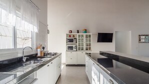 A modern kitchen with white cabinets, a black countertop, and a built-in microwave. - 5BR House w/ Gourmet Area 400m From Beach Rfi0316 (Picarras)