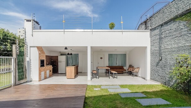 A modern house with a wooden deck, a grassy lawn, and a stone wall. - 5BR House w/ Gourmet Area 400m From Beach Rfi0316 (Picarras)