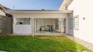 A modern house with a glass door entrance, a small patio, and a well-maintained lawn. - 5BR House w/ Gourmet Area 400m From Beach Rfi0316 (Picarras)