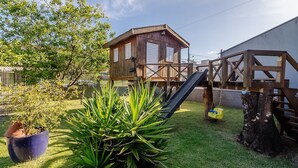 A wooden playhouse with a slide and a swing set in a backyard. - 5BR House w/ Gourmet Area 400m From Beach Rfi0316 (Picarras)