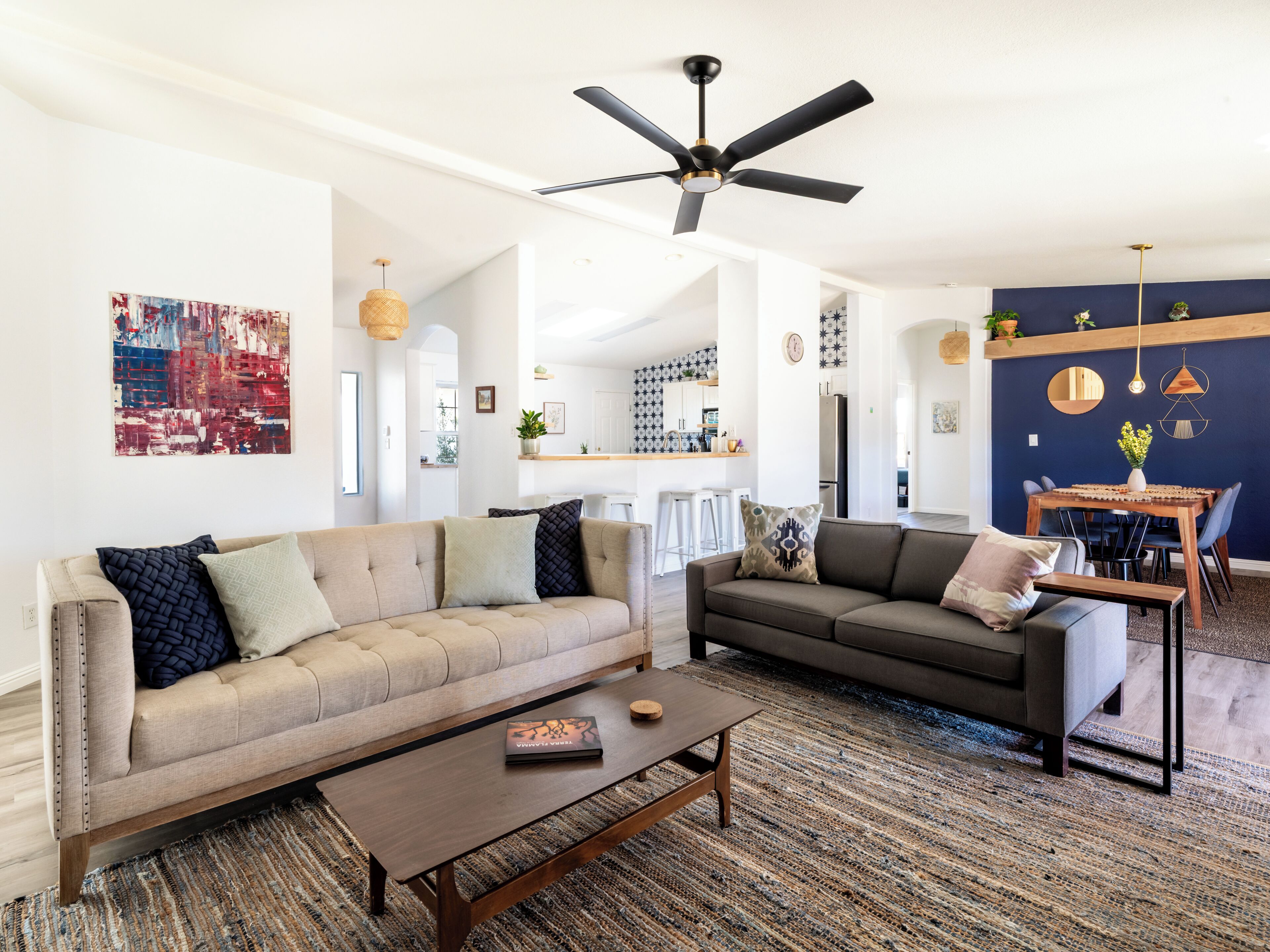 A living room with two sofas, a coffee table, and a ceiling fan.