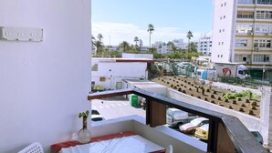 A balcony with a table, a chair, and a red box with a Christmas design. - Smiling Holiday Home (Playa del Inglés)
