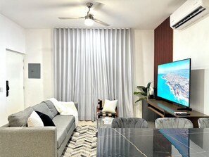 Habitación doble Deluxe | Sala de estar | Televisión LED de 65 pulgadas con canales por cable 