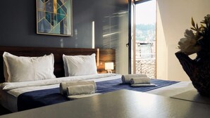Une chambre d’hôtel avec un lit, une table de chevet, une lampe et une vue sur l’extérieur.
