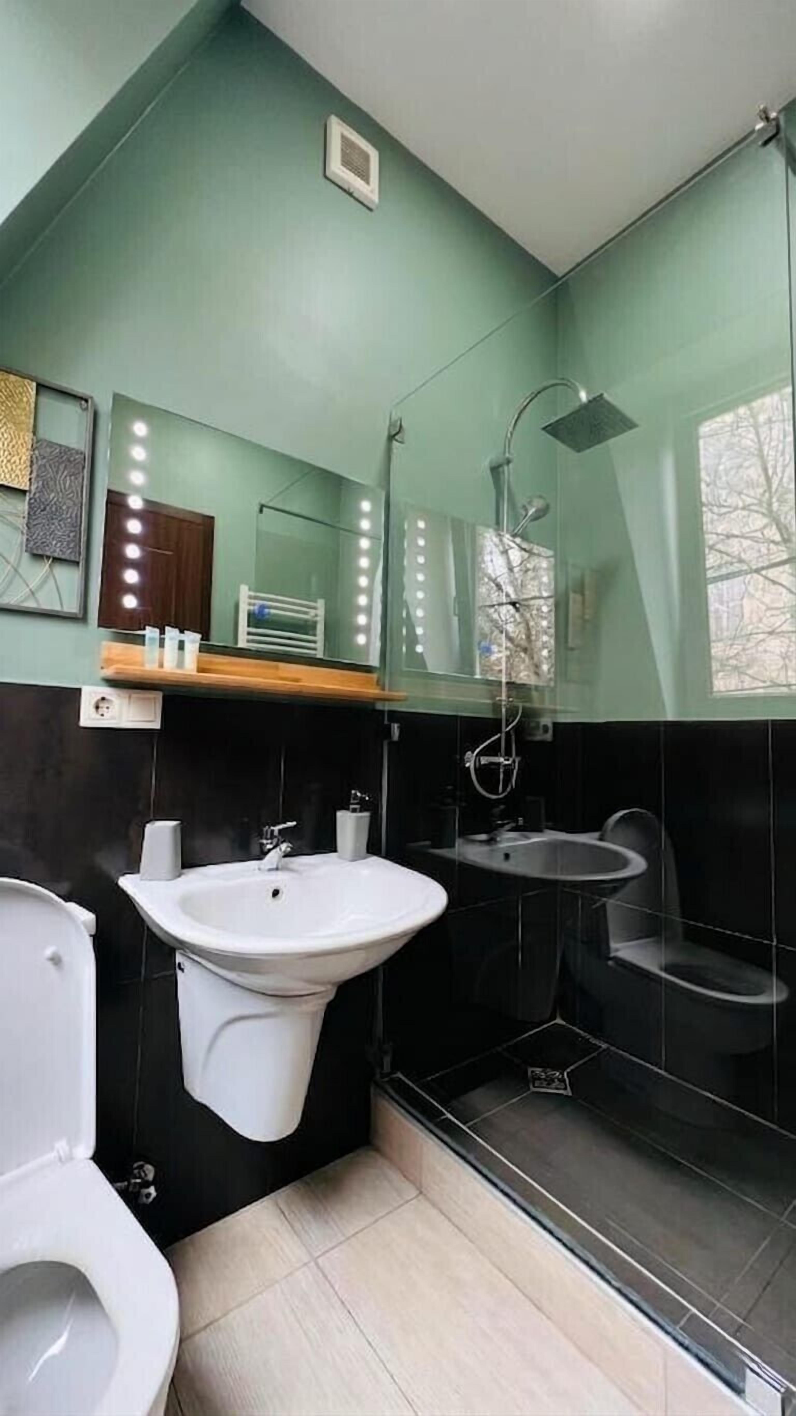 Une salle de bain moderne équipée d’un grand lavabo, de toilettes, d’un bidet et d’une douche.
