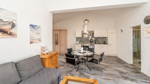 A compact living space with a dining area, kitchenette, and a sofa.