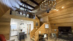 A spacious loft-style living area with a kitchen, dining area, and a cozy fireplace.