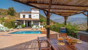 A villa with a swimming pool, outdoor seating, and a view of the hills. - Cortijo Miraflores Arenas by Ruralidays (Málaga)