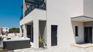 Een modern gebouw met een jacuzzi, een balkon en een deur.