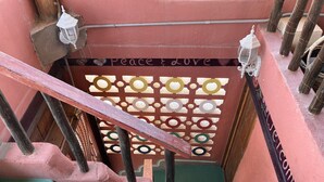 A staircase with a decorative panel featuring the words "Peace & Love" and a welcome sign.
