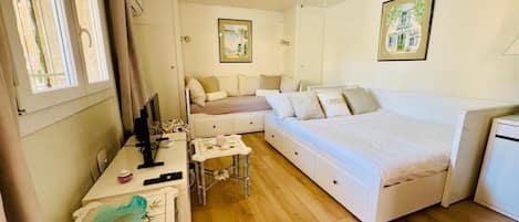 Tabla de planchar con plancha, internet y ropa de cama