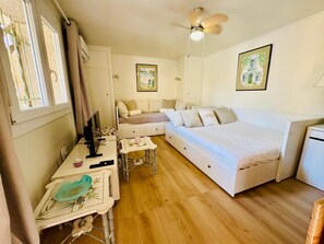 A compact bedroom with a bed, a desk, and a chair.