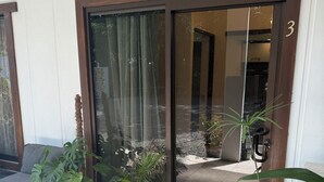 A hotel entrance with a sliding glass door, a doormat with "HOME" written on it, and potted plants outside. - Oasis by Franklin villa #3 (Provincia de Alajuela)