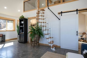 A modern interior with a staircase, a sliding door, and a plant. - Nestled in Nature Zion’s Gateway-Jacuzzi Suite (Apple Valley)