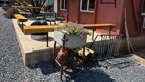 A rustic outdoor seating area with benches and a planter with flowers.