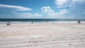 A beach with a lifeguard tower, sandy shore, and footprints. -  Studio for 2 with Breathtaking View with A/C (Daytona Beach Shores)