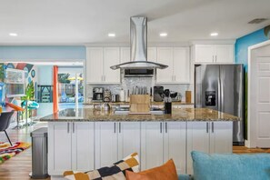 A modern kitchen with white cabinets, stainless steel appliances, and a granite countertop.