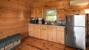 A wooden cabin kitchen with a stainless steel refrigerator, a microwave, a toaster, and wooden cabinets. - Cabin #4 The Sky Retreat - Off the Blue Ridge Parkway (Purlear)