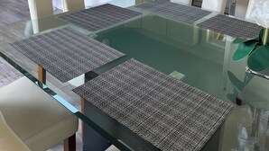 A modern kitchen with white cabinets, a central island, and a dining area with a glass table and chairs. - Cabin #14 The Sky Retreat - Off the Blue Ridge Parkway (Purlear)