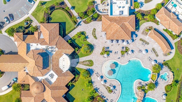 An aerial view of a resort with multiple swimming pools, sun loungers, and a well-maintained lawn area. - Enjoy views of the immaculate green from your screened lanai at Lakeside National - Golfside Escape (Bradenton)