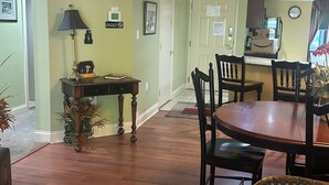 Un comedor con una mesa y sillas de madera, una lámpara y una planta en maceta.