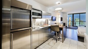 A modern kitchen with stainless steel appliances, a bar area, and a view of the city. - Strip View Studio • Balcony • No Resort Fee • Free Parking • TH27 (Las Vegas)