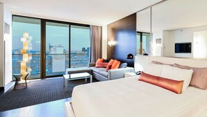 A modern hotel room with a large bed, a sofa, a small table, and a large window offering a city view. - Strip View Studio • Balcony • No Resort Fee • Free Parking • TH27 (Las Vegas)