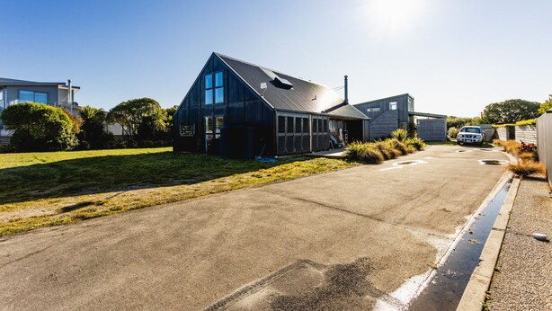 Une maison moderne dotée d’un grand garage, d’une allée et d’une pelouse bien entretenue.