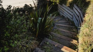 Un escalier en bois menant à une plage avec vue sur l’océan.