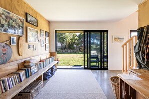 Un salon moderne avec une bibliothèque, une grande fenêtre et une vue sur l’extérieur.