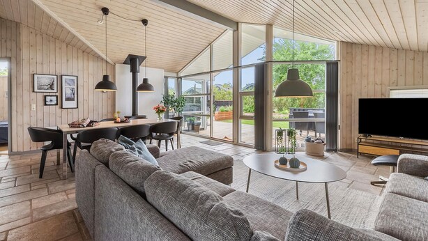 Una sala de estar moderna con un sofá grande, comedor y televisor.