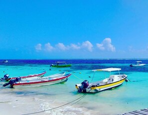 A beach with several boats anchored near the shore.