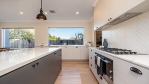 Una cocina moderna con una isla grande, estufa a gas y vistas al exterior.