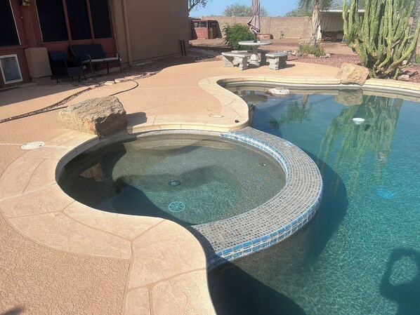 A swimming pool with a hot tub, surrounded by a patio area with outdoor furniture. - Horse Property 3-Bed plus office, 2 bath house, pool and spa (Wittmann)
