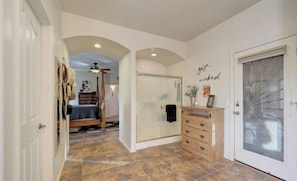 A hallway with a bed, a vanity, and a door with frosted glass. - Horse Property 3-Bed plus office, 2 bath house, pool and spa (Wittmann)