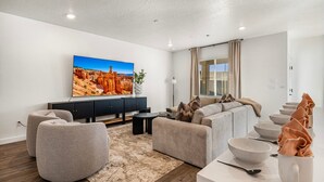 A modern living room with a sectional sofa, a flat-screen TV, and a dining area with bowls and a spoon. - Skyline 1649, Hot Tub, Nintendo Switch, Community Amenities! (Washington)
