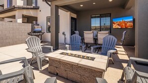An outdoor patio with a stone fire table, Adirondack chairs, and a grill. - Skyline 1694, Hot Tub, Arcade Games, Nintendo Switch, Community Amenities! (Washington)