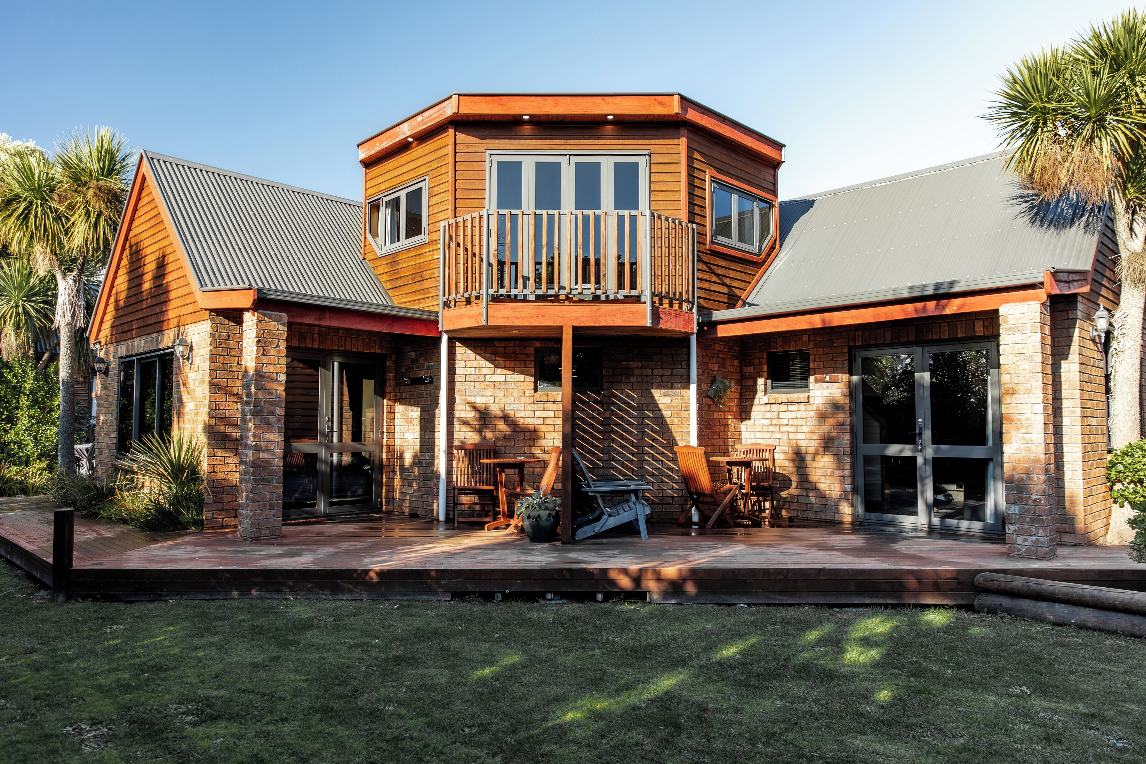 Een tweelaags huis met een balkon, een overdekte veranda en een gevel van baksteen.