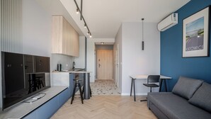 A modern apartment with a kitchenette, a dining area, and a living room.