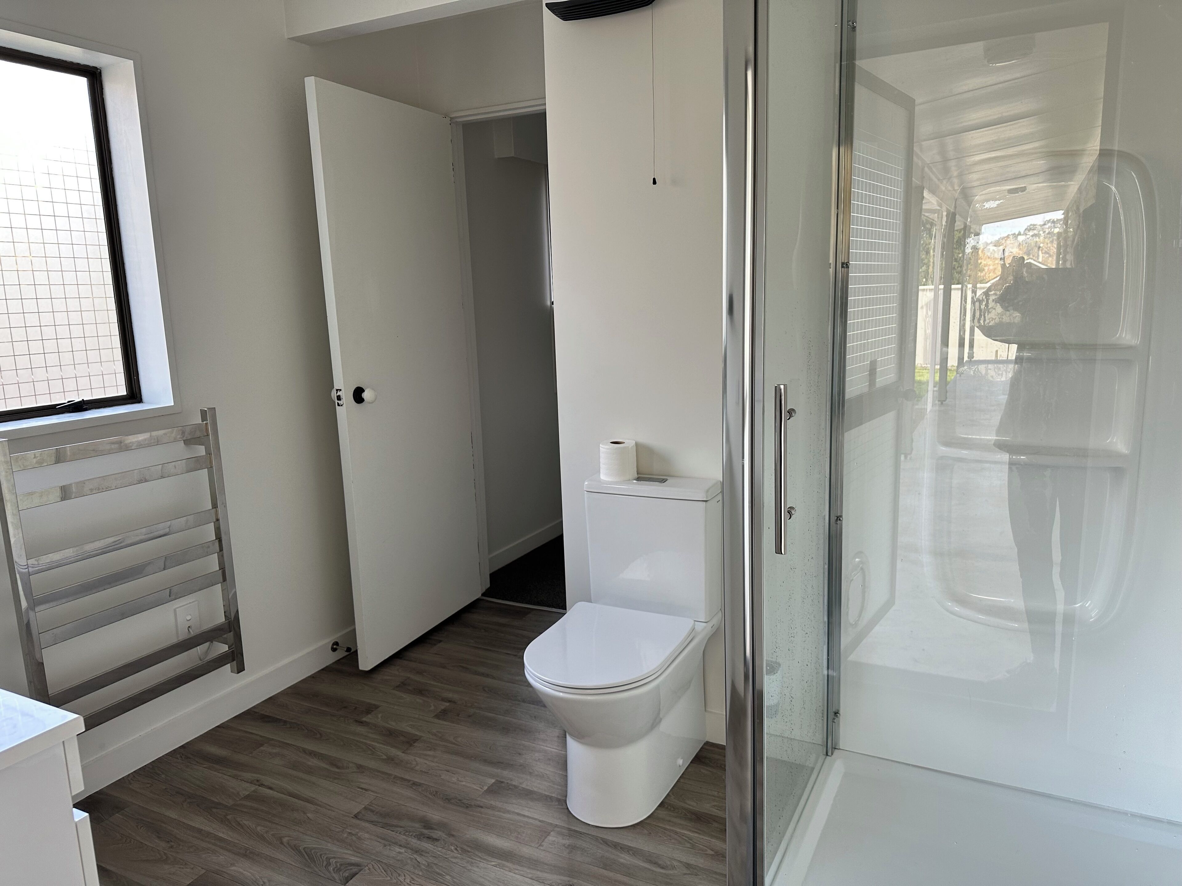 Een douche, handdoeken, zeep, toiletpapier