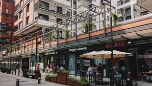 An urban street with outdoor seating at a cafe named 'Perfect Beauty'.