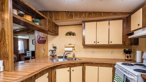 A kitchen with wooden cabinets, a sink, and a stove. - Charming Canal Waterfront 3/2 in Salt Springs (Salt Springs)